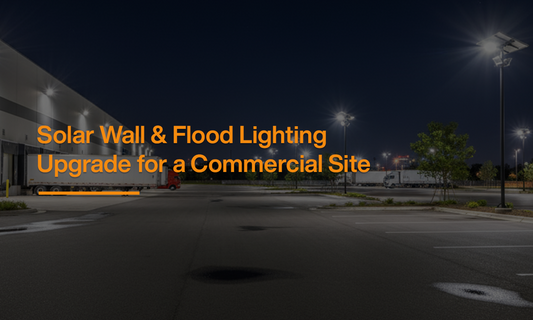 Commercial site illuminated at night with solar wall pack lights and solar flood lighting systems installed across the parking and building perimeter.
